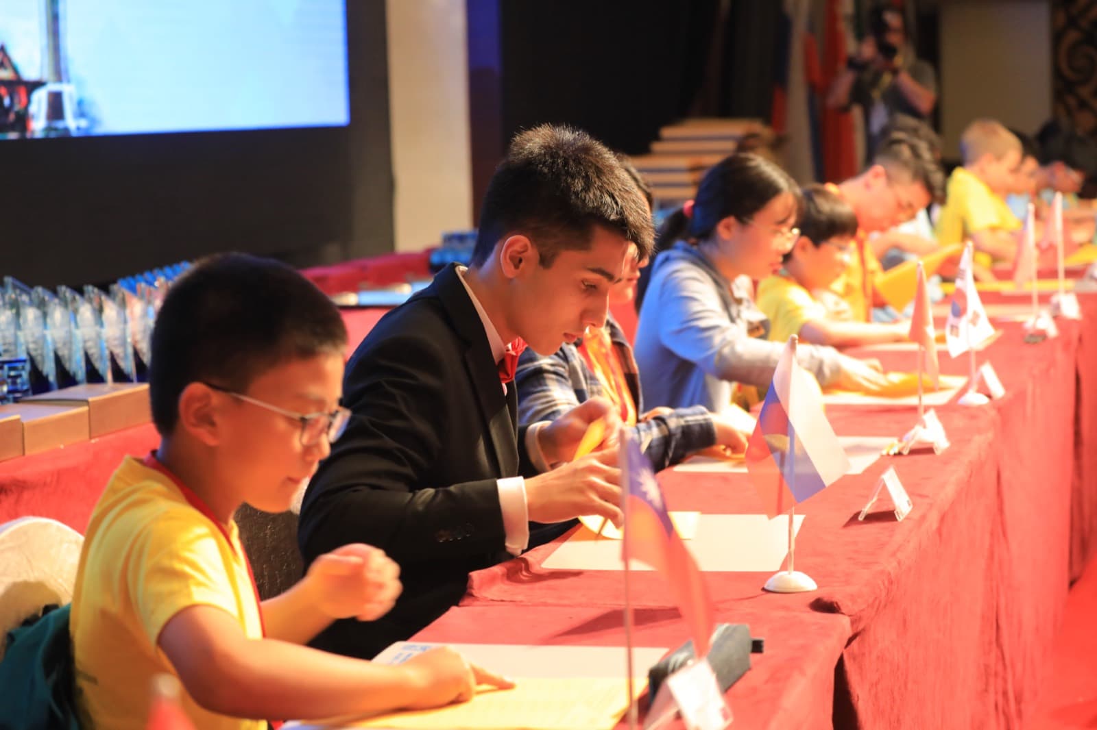 Students in school uniforms calculating at a PAMA international competition